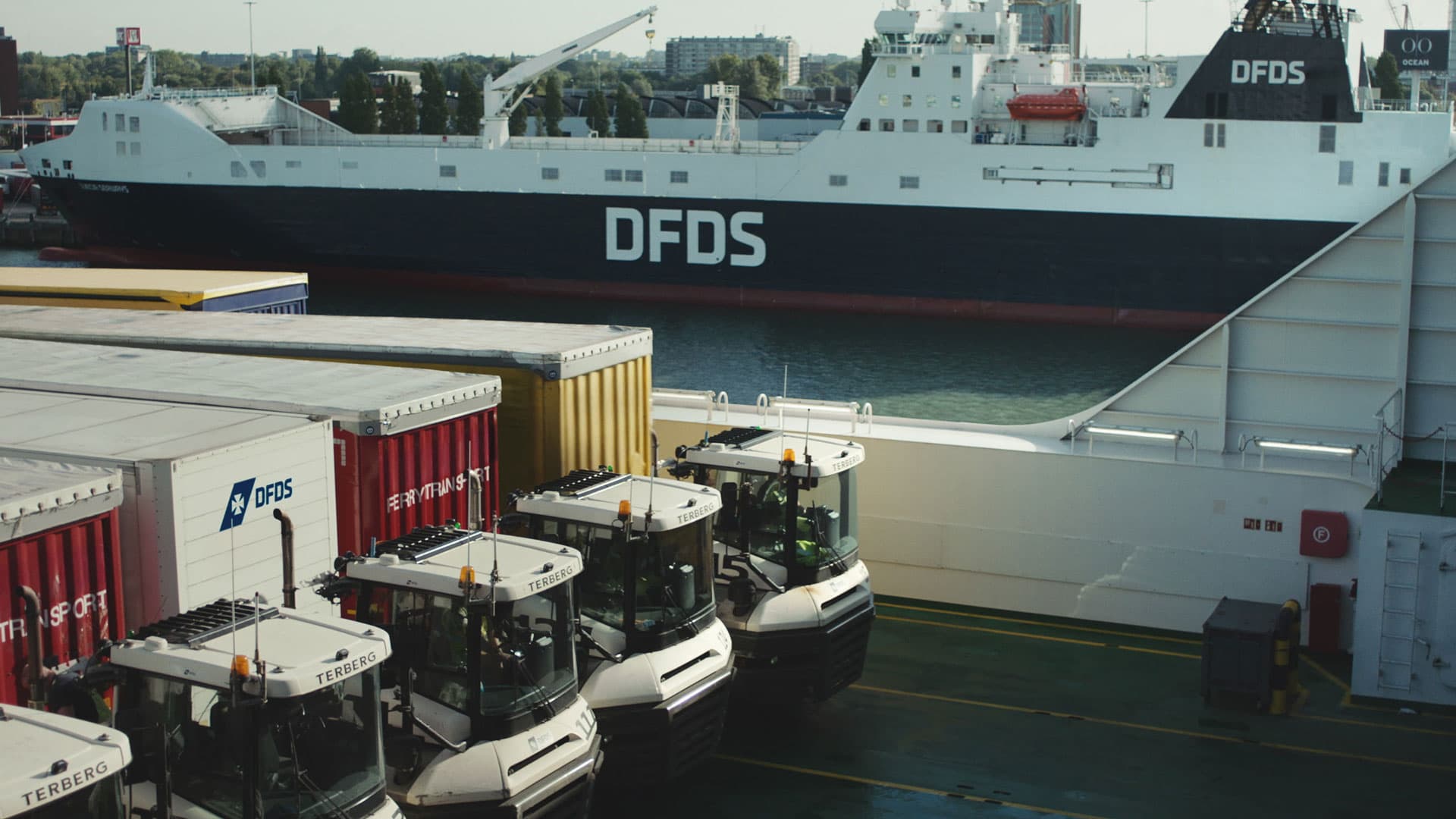 DFDS trucks loading trailers onboard a ship.