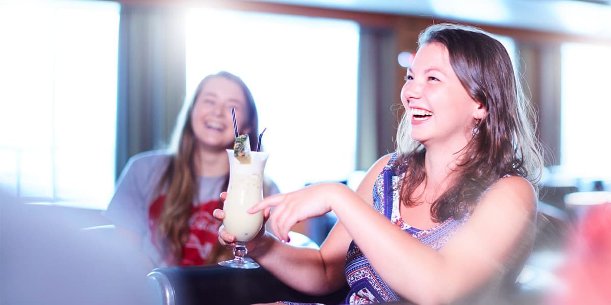 Friends enjoying a cocktail onboard Newcastle-Amsterdam
