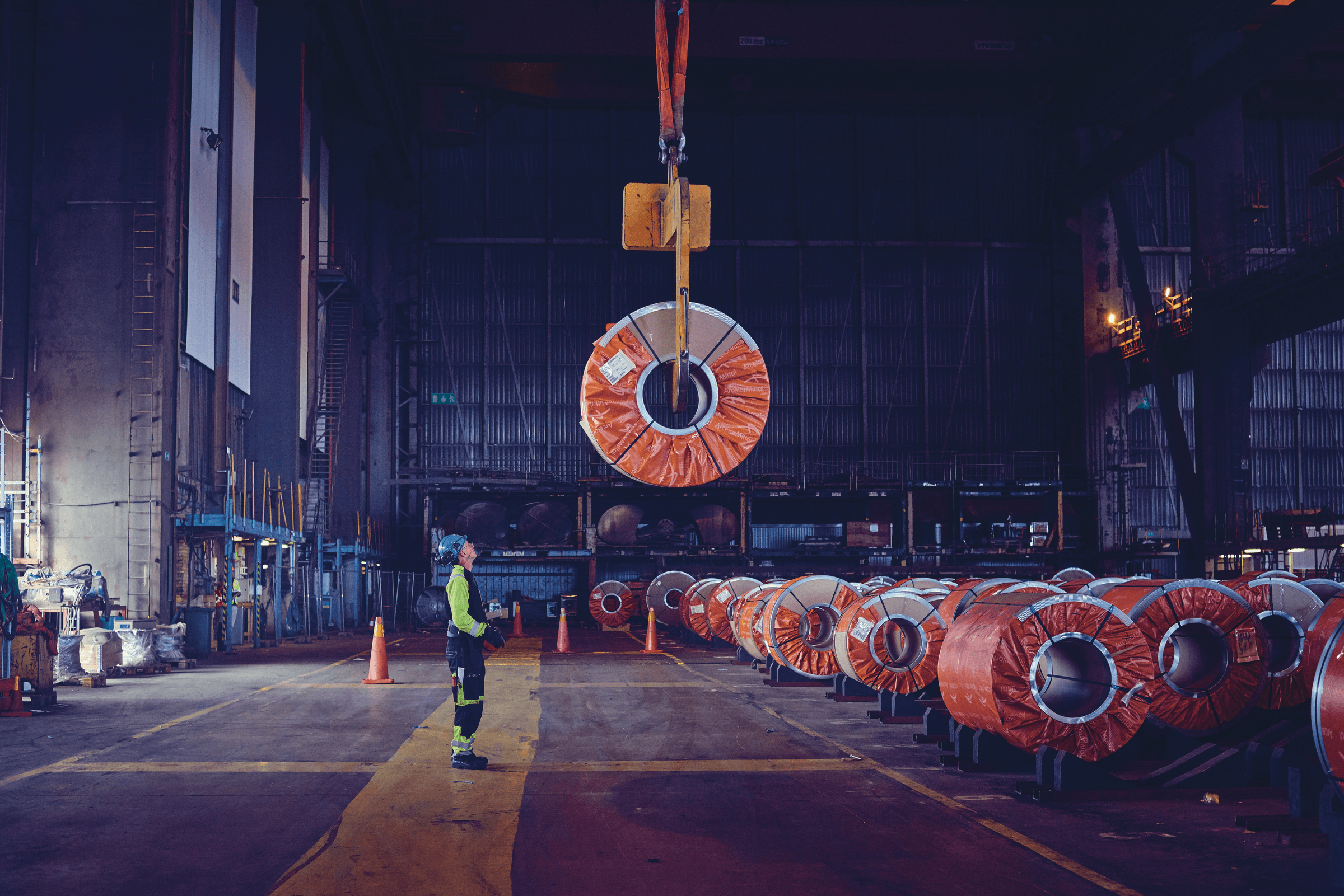 A DFDS Logistics employee loading metal coils at a steel terminal