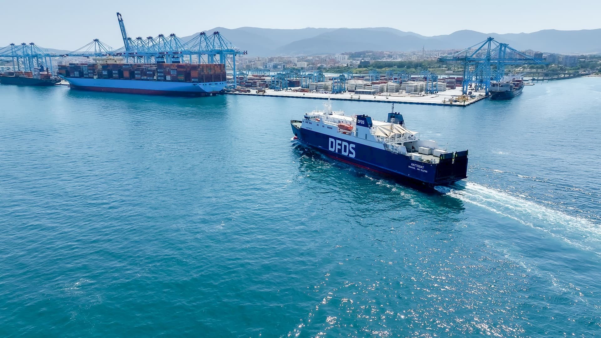 DFDS vessel Kattegat in harbour, with an unloading container ship in the background