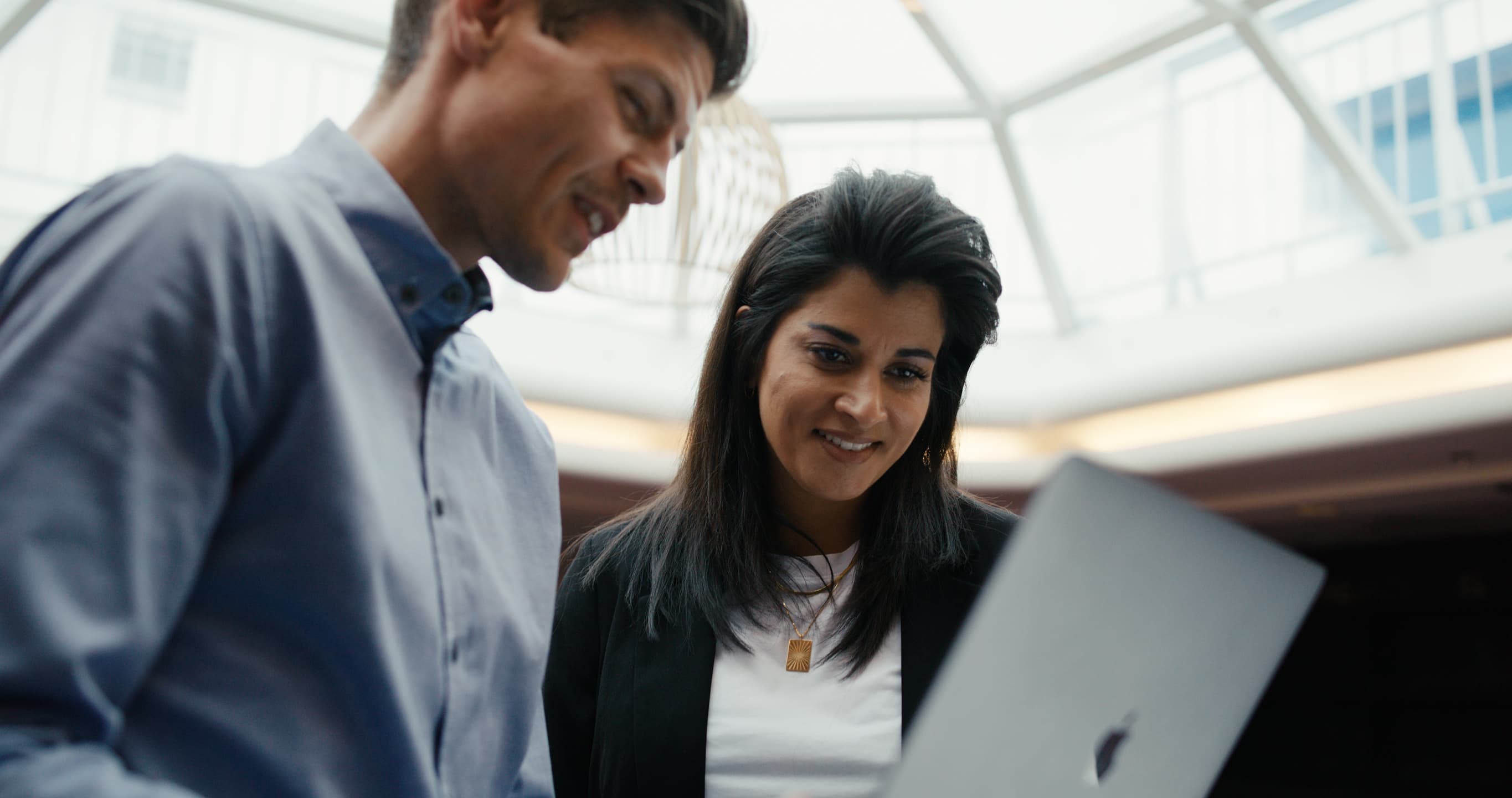 Two DFDS employees looking at a laptop inside a building
