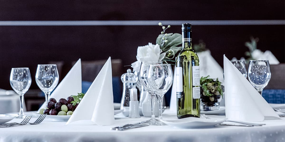 Tavolata con bicchieri e bottiglie di vino
