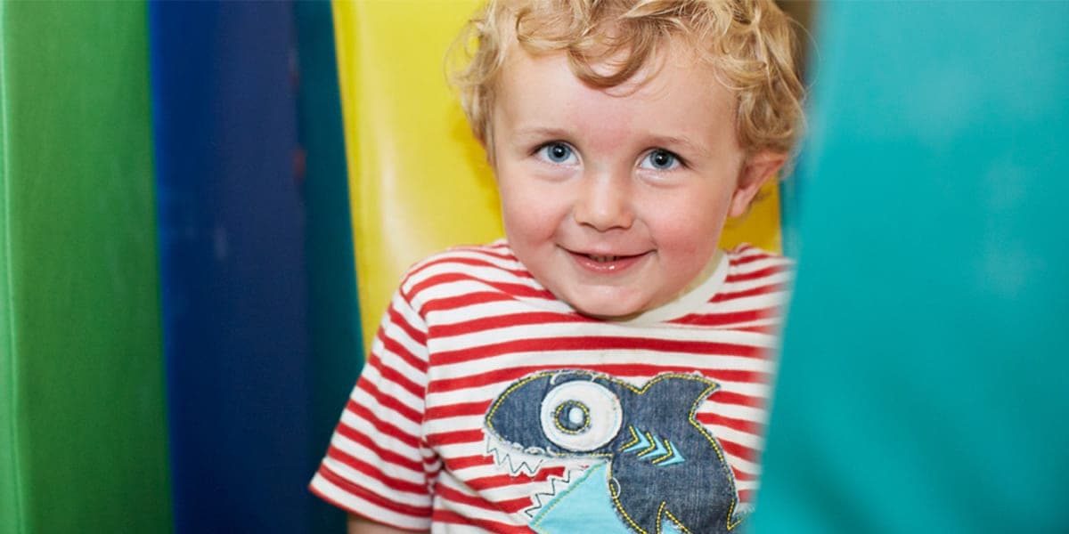 Little boy smiling in the childrens play area on the ferry